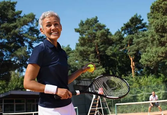 Frau über 60 beim Tennisspielen ohne Brille