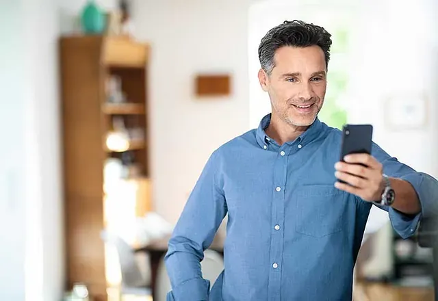 Mann liest sein Handy ohne Lesebrille
