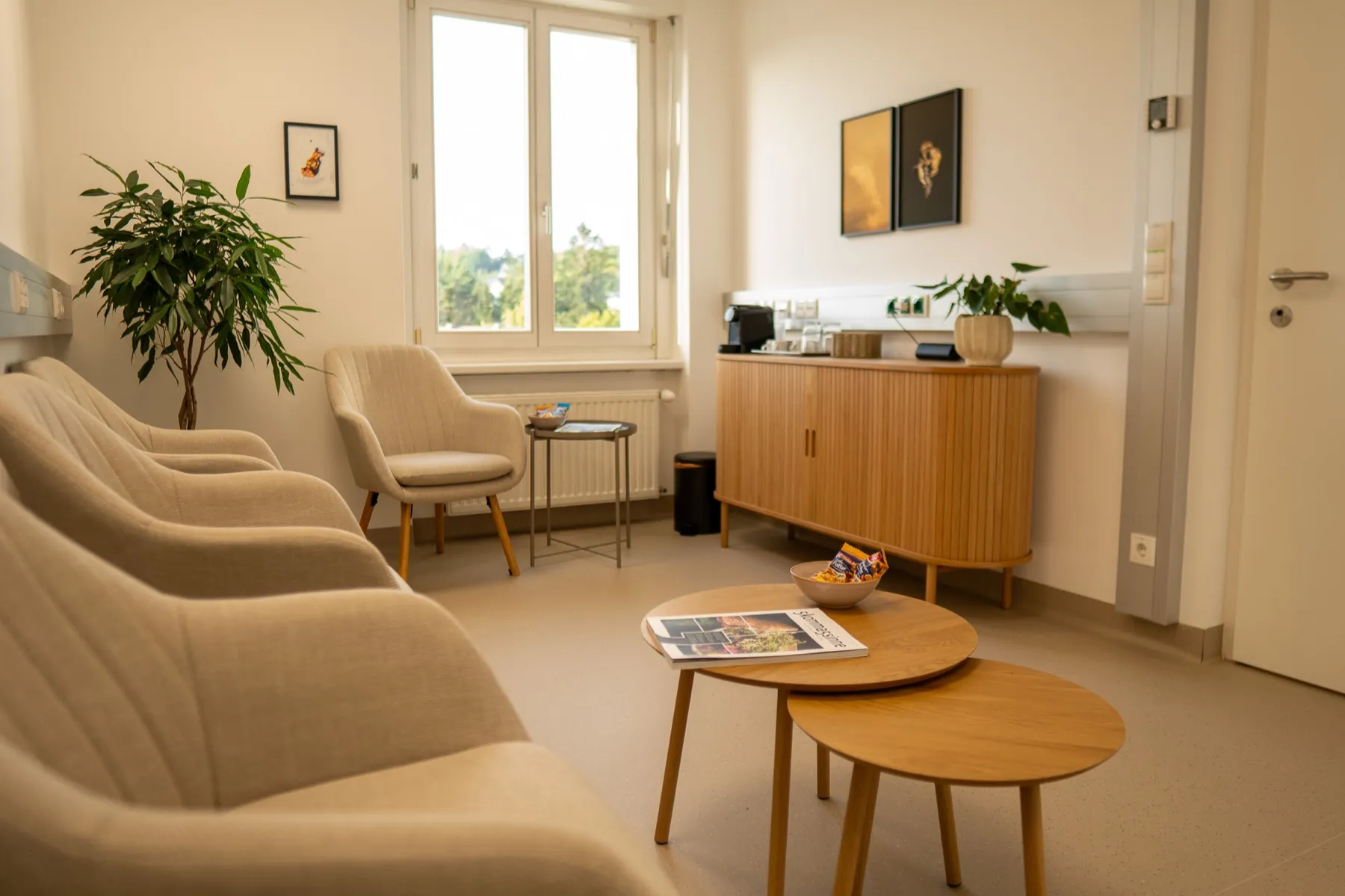 Wartebereich der Privatordination mit hellen Sesseln, Tischen und Zeitschriften