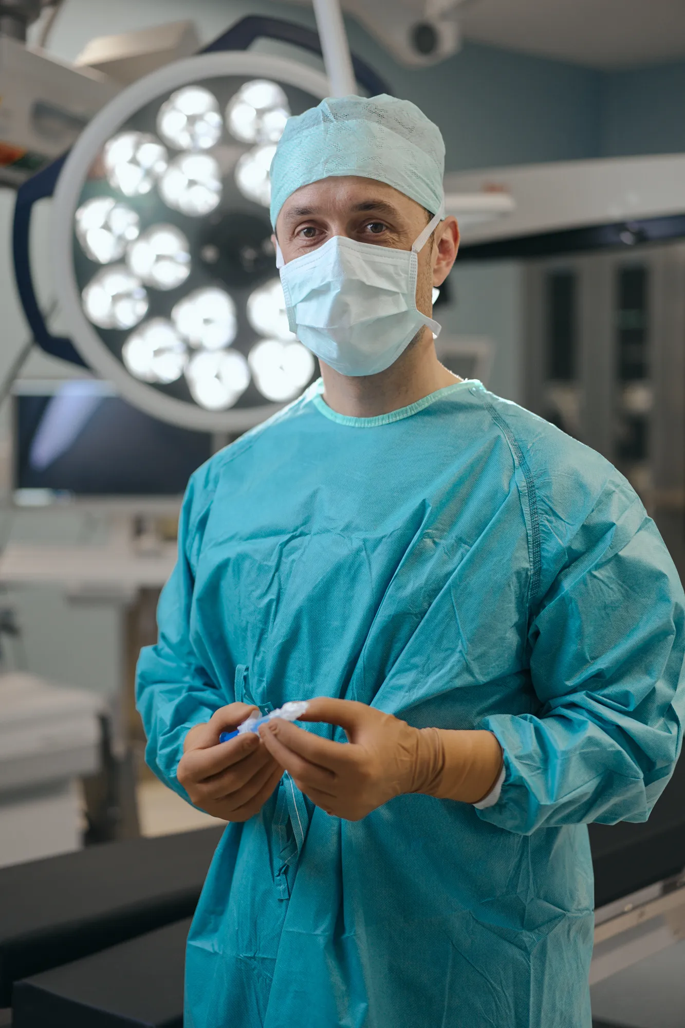 Dr. Steinwender im Operationssaal mit Kunstlinse in der Hand